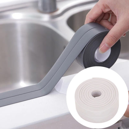 Grey waterproof adhesive sealing tape, hand applying along sink edge and corner