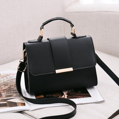 Black small flap crossbody bag with gold-tone hardware and adjustable strap