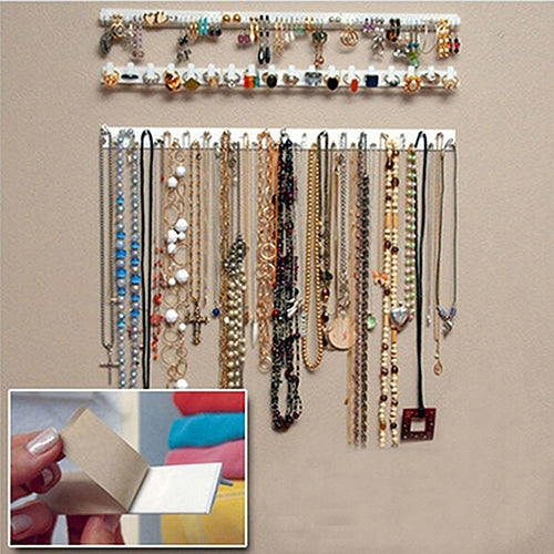 Adhesive jewelry hook rails holding necklaces on a wall, with application inset