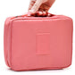 Coral pink zippered cosmetic toiletry organizer bag with front logo patch.