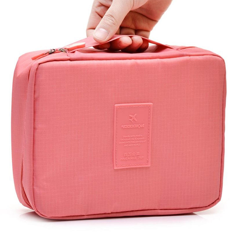 Coral pink zippered cosmetic toiletry organizer bag with front logo patch.