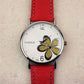 Ladies quartz watch with red leather strap, silver case, white dial with gold glitter four-leaf clover
