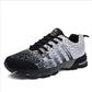 Black and white trekking sneakers with lace-up front, padded collar, and tread sole