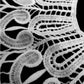White lace embroidered fake collar close-up showing intricate swirl cutwork