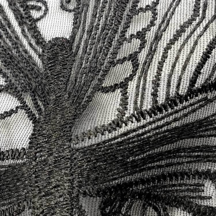 Close-up butterfly lace collar embroidery, textured black thread on light base