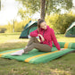 Green double inflatable camping air cushion with yellow stripes on outdoor grass