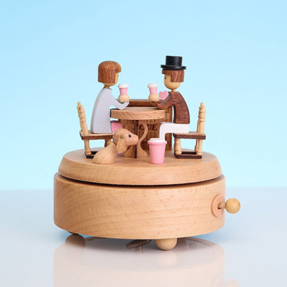 Lover-themed wooden rotating music box with two figures and pink tableware on round base