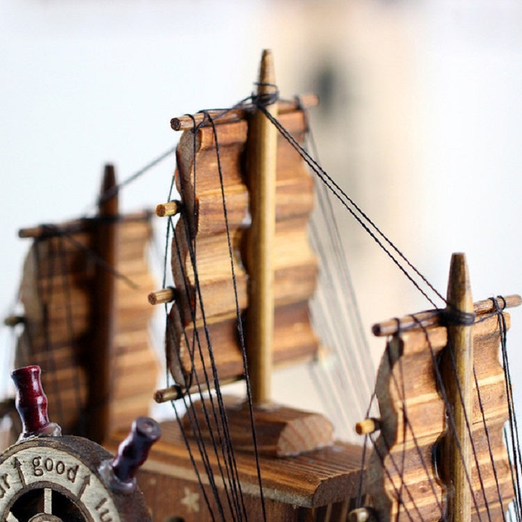 Wooden sailboat decoration with stacked decks, sails, and taut rope rigging lines