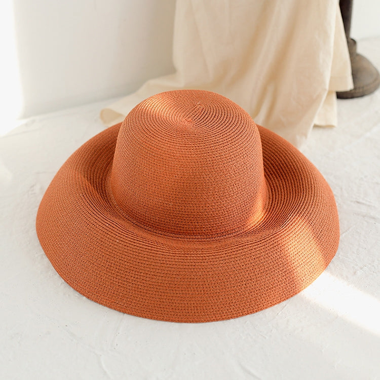 Orange woven straw sun hat with wide brim and smooth curved crown