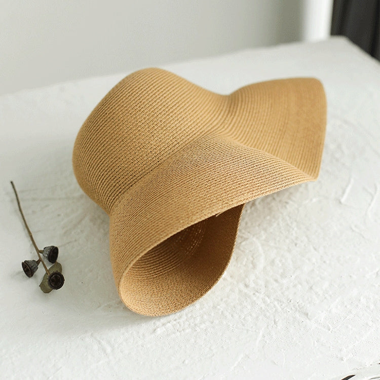 Beige woven straw sun hat with wide brim and curved crown, folded detail
