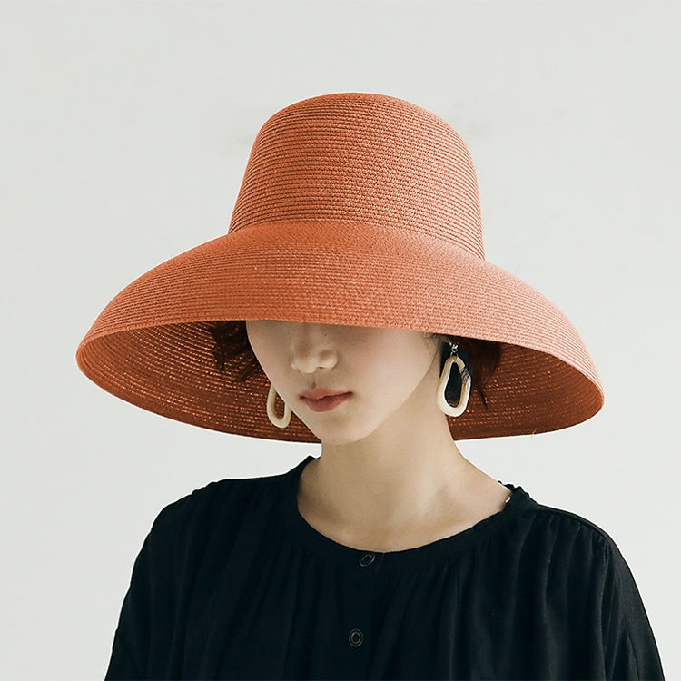 Wide-brim straw sun hat in rust orange, floppy basin style with curved brim