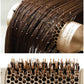 Round ceramic hair brush with dense bristle bed, used on hair near a gold barrel