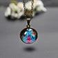 Round galaxy globe pendant hanging from gold chain, close-up
