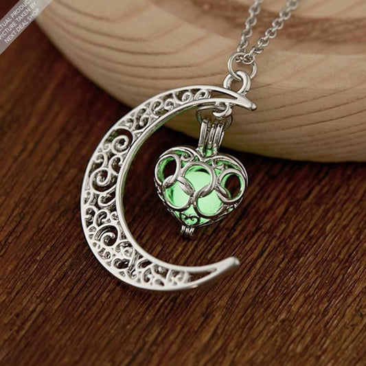 Silver crescent moon charm necklace with filigree design and green luminous gem pendant