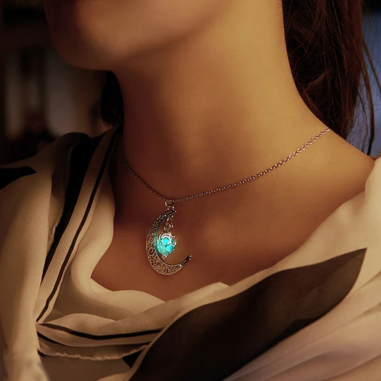 Green glowing crescent moon charm necklace on model with delicate silver chain