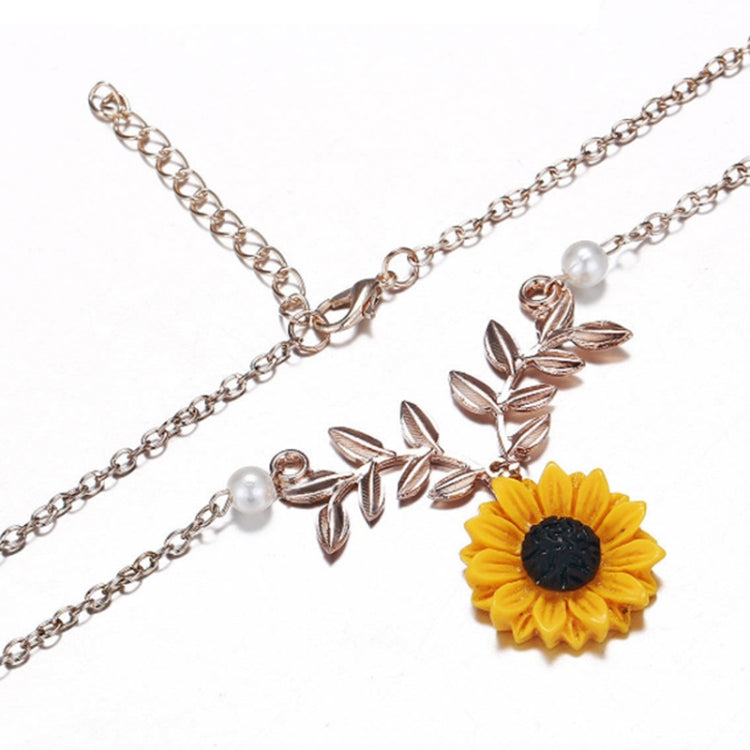Rose gold sunflower pendant necklace close-up with faux pearl beads and leaf branch charm