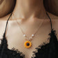 Sunflower pendant necklace on model: rose gold chain with faux pearl beads and leaf charm