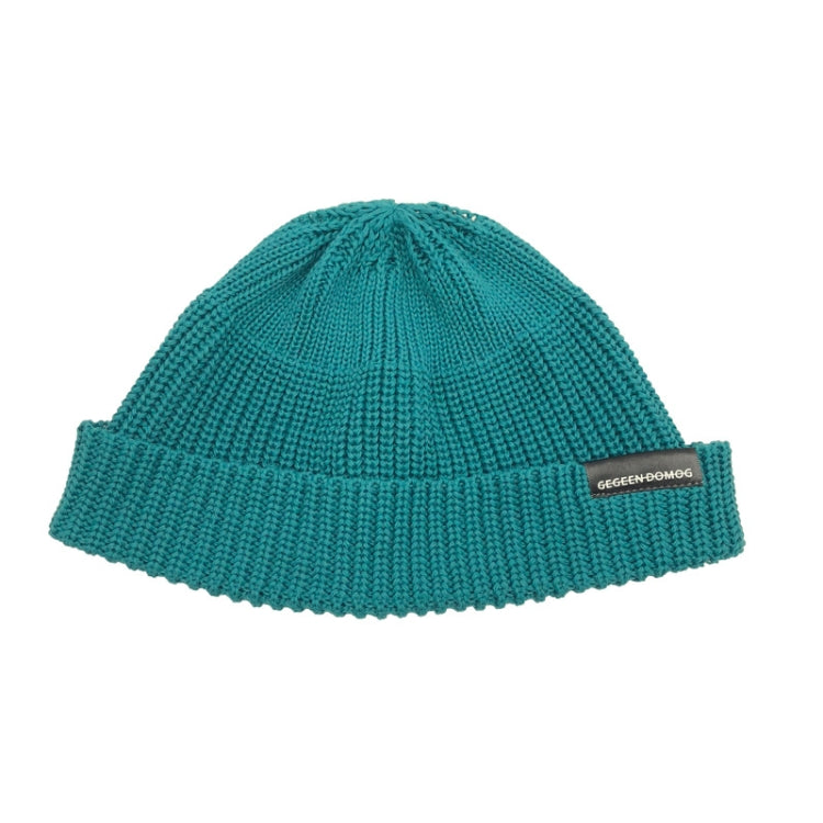 Teal knitted beanie hat with ribbed brim and pom top, one-size, branded label.