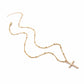 Gold cross pendant necklace lying flat, featuring a small cross charm on a linked chain.