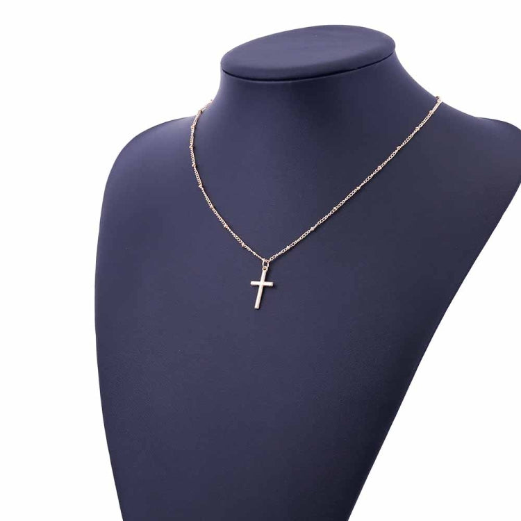 Silver cross pendant necklace on a mannequin with a delicate chain and small cross charm.