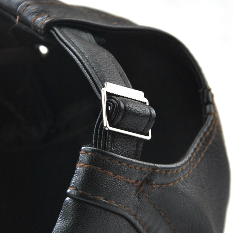 Close-up of black PU leather peaked cap side strap with metal buckle and stitch seam.