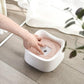 White floating pet water bowl with pink tray insert, held by hand while filling