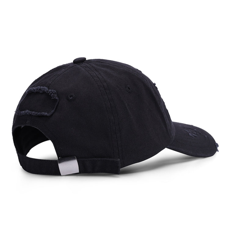 Washed black baseball cap shown from side with distressed patches and torn brim