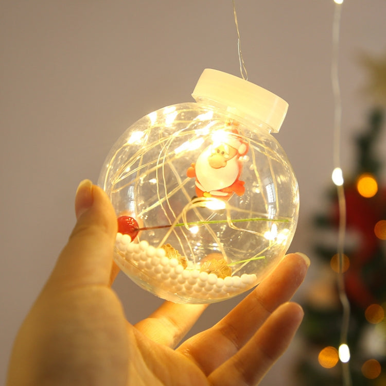 Warm white LED globe lamp bead with clear shell and small figurine, held in hands