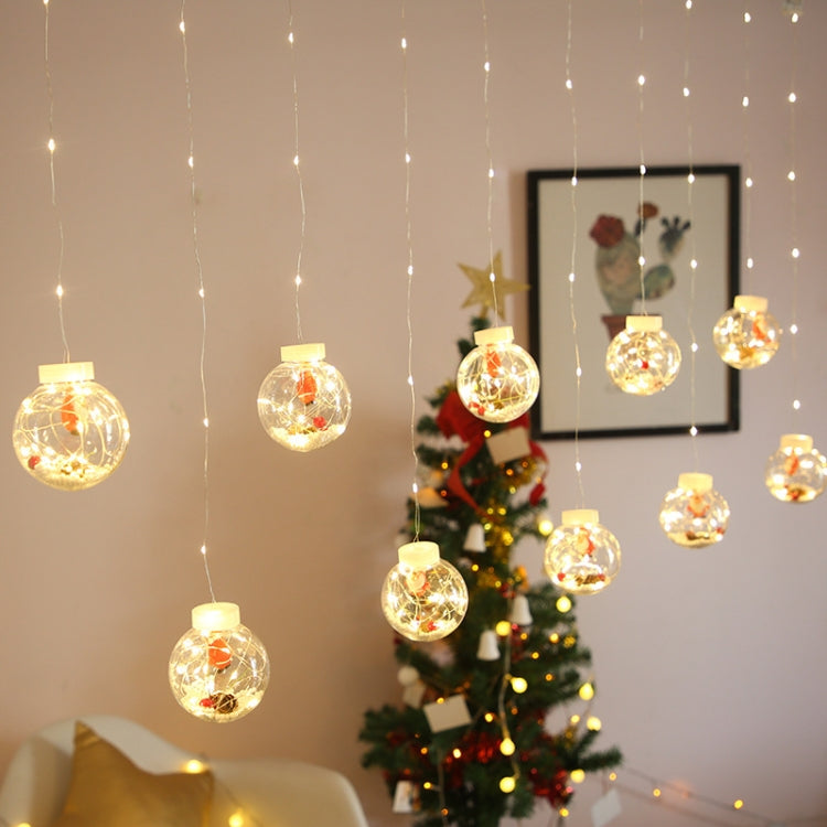 Warm white LED globe curtain lights with clear ornaments hanging near a decorated tree