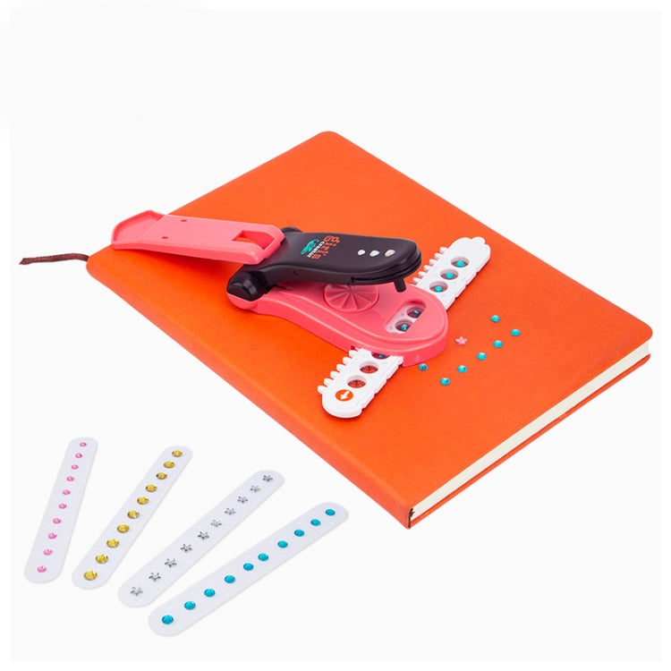 Red sticker-diamond nailing machine toy on an orange notebook with diamond strip pieces