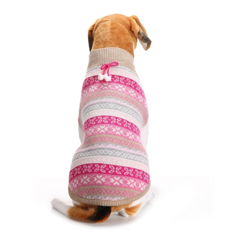 Dog wearing knitted sweater, pink and white striped snowflake pattern on tan fur