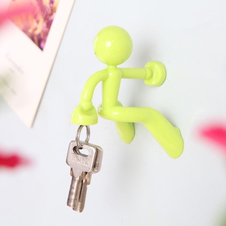 Lime green humanoid magnet key hanger holding a pair of metal keys.