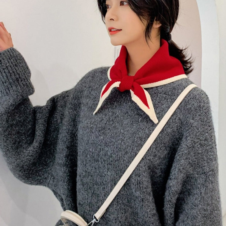 Red and cream knitted wool triangle scarf with white stripes, worn on neck