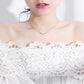 Sterling silver necklace on model with small link charms at collarbone