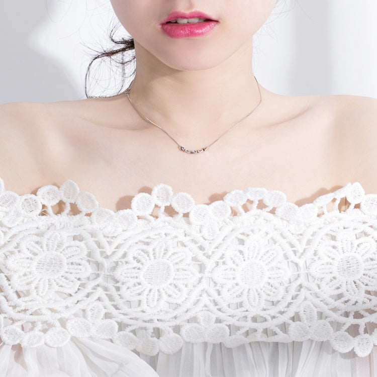 Sterling silver necklace on model with small link charms at collarbone
