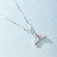 Silver whale-tail pendant necklace with sparkling detail, side view