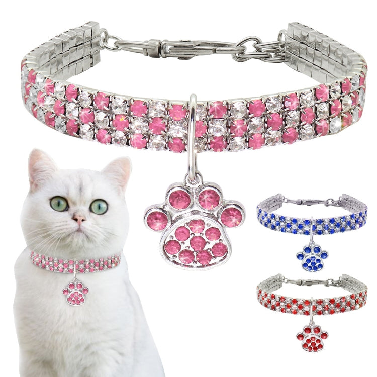 Pink rhinestone pet collar with paw charm and clasp, shown on a cat