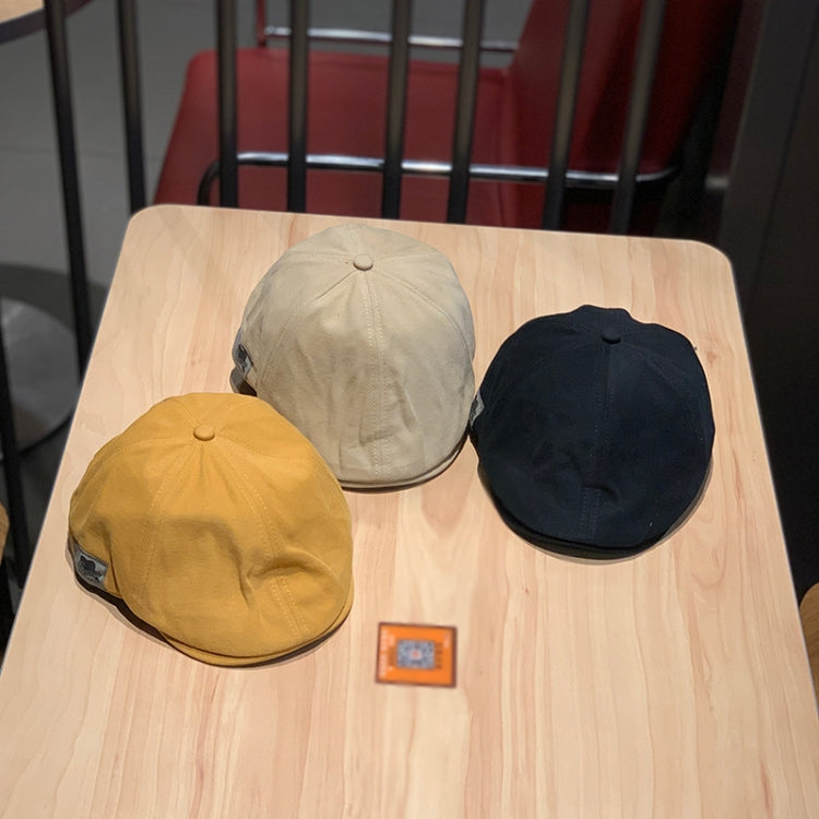 Three newsboy caps: black, cream, and mustard, with curved brims