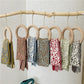 Kids knitted leopard-pattern scarves, multiple colors hanging on a rack