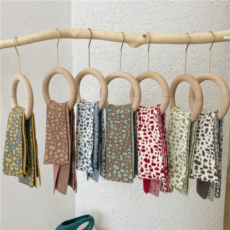 Kids knitted leopard-pattern scarves, multiple colors hanging on a rack