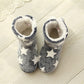 Dark blue-gray winter boot slippers with white stars, showing plush inner lining and collar