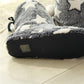 Bottom view of dark blue-gray boot slippers with textured tread sole and star upper
