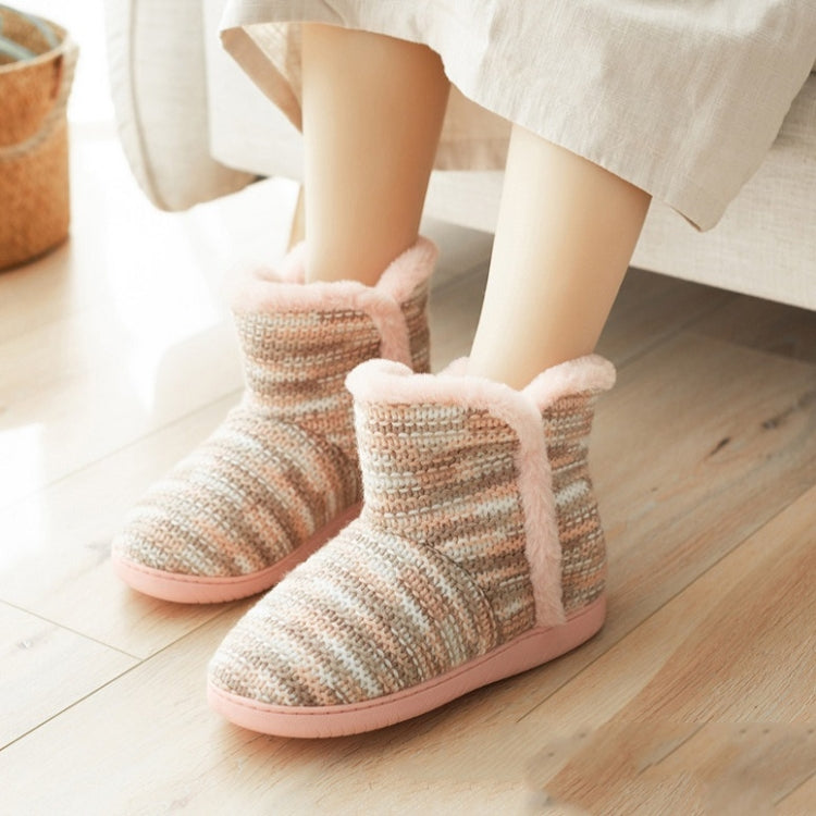 Beige knit indoor slippers with pink fuzzy trim, worn with light pants at home.