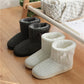 White and gray winter slipper boots on wooden floor with thick soles