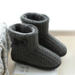 Gray cable knit slipper boots with bow and cushioned interior