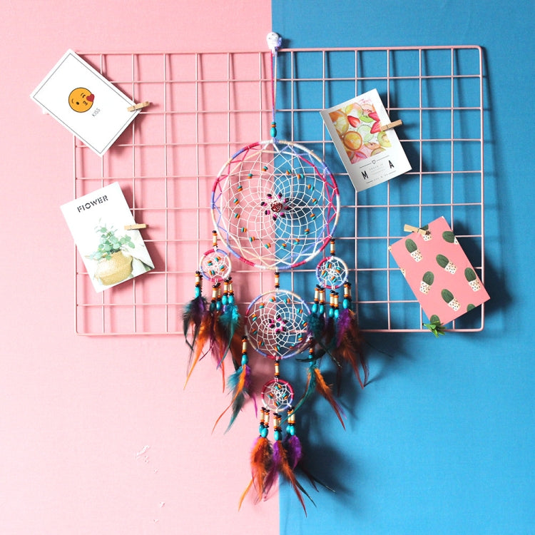 Colorful dream catcher wall hanging with multiple hoops, feathers, and hanging bead charms