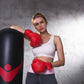 Red boxing gloves with hook-and-loop closure, worn with wrist wraps visible.