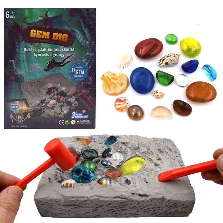 Gem dig excavation toy set with gray rock, colorful gems, and orange digging tools