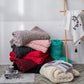 Folded chunky wool knit blankets in pink, gray, burgundy, teal, and dark gray