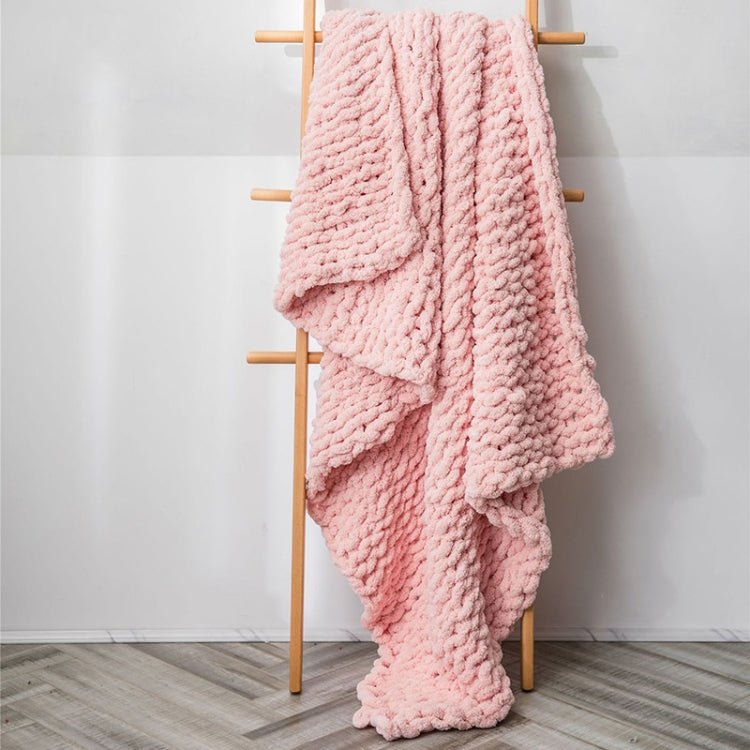 Thick knitted wool blanket, pink, folded and draped over a stand